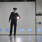 Security guard with torch in warehouse